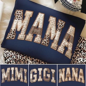 May include: Navy blue sweatshirt with the word "MAMA" appliqued in a patchwork design featuring leopard print, floral, and plaid patterns. Additional images show "MIMI", "GIGI", and "NANA" in similar styles.