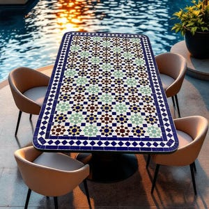 Op de afbeelding: Een vierkante eettafel met een mozaïek tafelblad met een geometrisch patroon in tinten blauw, groen, bruin en wit. De tafel wordt omringd door vier beige stoelen met zwarte metalen frames.