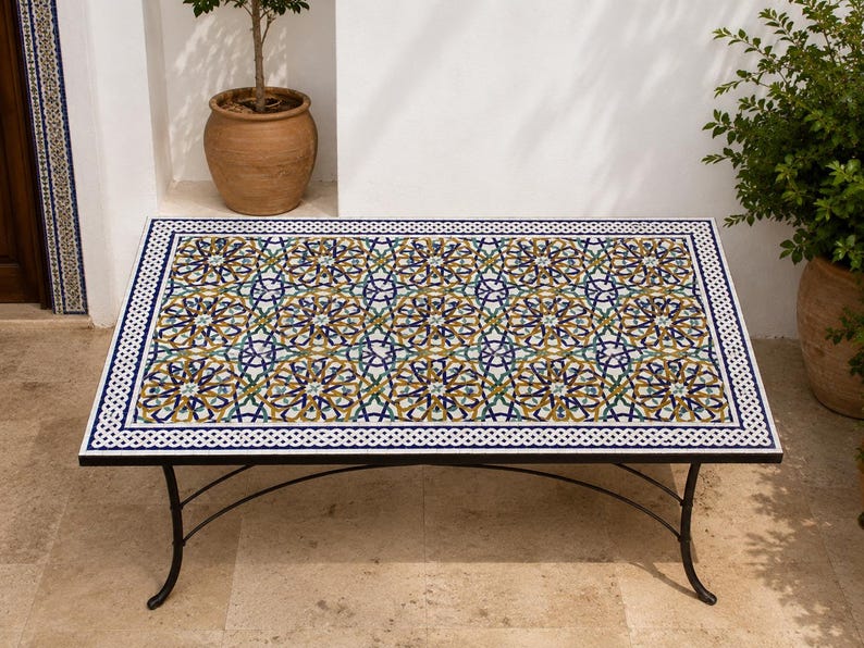 May include: A rectangular table featuring a mosaic tile top with a repeating geometric star pattern in shades of blue, green, yellow, and white. The table has a black metal frame with four curved legs and a decorative border around the edge.