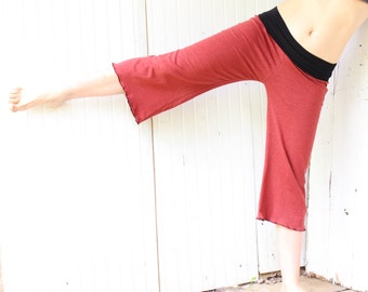May include: A woman wearing red wide-leg pants with a black waistband. The pants have a relaxed fit and a slightly cropped length.