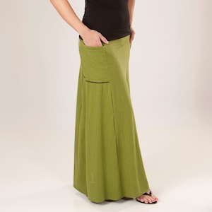 Może przedstawiać: Długa, zwiewna spódnica w kolorze zielonym z czarnym wykończeniem i jedną kieszenią po lewej stronie.