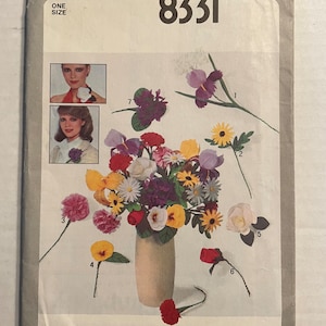 May include: Simplicity sewing pattern number 8331 for making fabric flowers. The pattern includes instructions for making a variety of flowers, including roses, carnations, daisies, and irises. The pattern is for one size.
