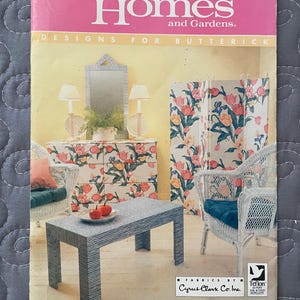 May include: A vintage pattern cover for "Better Homes and Gardens" featuring a room scene with floral-patterned furniture, including a dresser, screen, and wicker chairs. The cover is pink and has the text "Designs for Butterick."