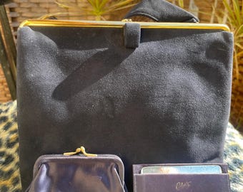 May include: A vintage navy blue handbag with a gold-tone clasp and handle. A matching coin purse and cardholder are in front of the handbag. The cardholder has gold text that reads "Tiffany & Co."