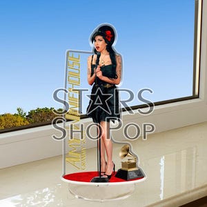 Peut inclure: Un présentoir en acrylique transparent avec un tapis rouge et une statuette dorée des Grammy Awards. Une figurine en noir et blanc d'Amy Winehouse se tient sur le tapis rouge tenant un microphone. Le présentoir porte l'inscription "Amy Winehouse Grammy 2007" sur le côté.