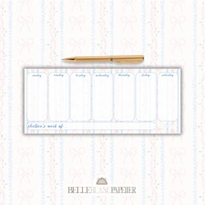 May include: A weekly planner with a light blue and pink bow and floral pattern background. The planner has a light blue border and includes the days of the week. A gold pen rests on the planner.