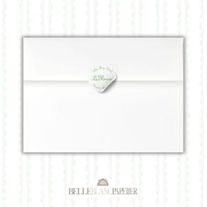 May include: A white envelope sealed with a round sticker. The sticker features the text "Le Blanc" in a script font, along with an address in green. The bottom of the image has the text "Belle Blanc Papier".