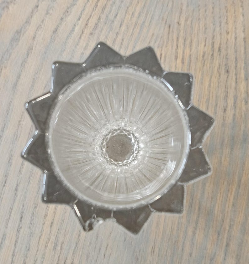 Pu&ograve; includere: Portacandele in vetro trasparente con un design a forma di stella. Il supporto ha una base a forma di stella e un interno a coste. Il vetro &egrave; trasparente. Un pezzo decorativo per candele.