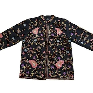 May include: A black long-sleeved jacket featuring a mandarin collar and a front button closure. The garment is decorated with intricate, colorful floral and paisley embroidery in shades of pink, purple, and light blue, with orange vines.