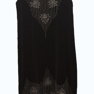 May include: A sleeveless black dress featuring gold beadwork in a floral pattern around the neckline and hem. The design includes vertical beaded lines extending from the floral motifs, creating a structured look on the dark fabric.