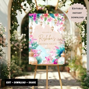 May include: A printable welcome sign for a Mehndi night celebration. The sign features a watercolor background with pink and blue flowers, green leaves, and gold lanterns. The text on the sign reads "Welcome to Rishika's Mehndi Night 08.09.25".