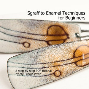 May include: A pair of earrings with a white and brown enamel design. The earrings feature a sgraffito technique, which is a decorative technique that involves scratching through a layer of enamel to reveal the underlying layer. The earrings are titled "Sgraffito Enamel Techniques for Beginners" and include a step-by-step PDF tutorial by My Brown Wren.