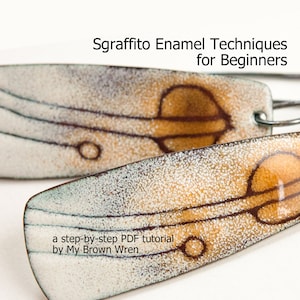 May include: A pair of earrings with a white and brown enamel design. The earrings feature a sgraffito technique, which is a decorative technique that involves scratching through a layer of enamel to reveal the underlying layer. The earrings are titled "Sgraffito Enamel Techniques for Beginners" and include a step-by-step PDF tutorial by My Brown Wren.