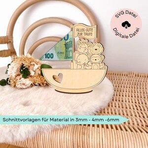 May include: Wooden sailboat money holder with a heart cutout and a banner that reads "Alles Gute zur Taufe". The sailboat is decorated with a giraffe, lion, elephant, and monkey. The sailboat is sitting on a wicker chair with a white faux fur throw.