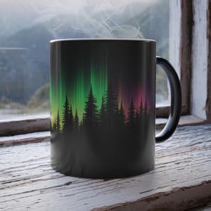 May include: Black coffee mug with a design of a forest silhouette against a colorful aurora borealis backdrop.