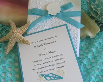 Convite de casamento na praia com conchas e renda