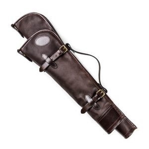 Puede incluir: Un estuche para armas de cuero marrón oscuro con hebillas de latón y una correa de transporte. El estuche está diseñado para guardar un arma larga y tiene un cierre de solapa. El cuero parece ser de alta calidad y estar bien cosido.