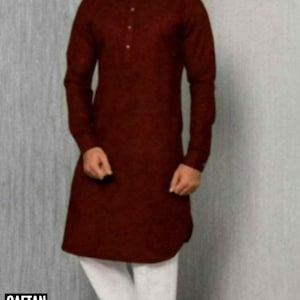 Puede incluir: Una camisa de manga larga de color marrón con cuello mandarín y cierre de botones. La camisa se lleva con pantalones blancos.
