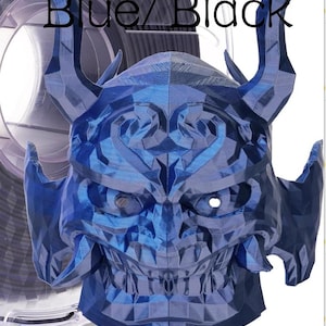 May include: A 3D printed mask with a geometric, faceted surface in a metallic blue and black finish. The mask features two prominent curved horns, a wide grin with visible teeth, and eye openings. The text Blue/Black is printed above.