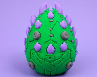 May include: An egg-shaped object with a bright green textured surface featuring mechanical panel lines and small gray circular details. The exterior is adorned with numerous pointed purple spikes arranged in rows along the top and sides.