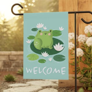 May include: A green frog with a happy face sits on a lily pad surrounded by water lilies and green lily pads. The background is a light blue color. The text "WELCOME" is printed in white at the bottom of the image.