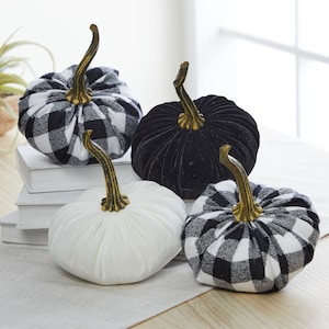 May include: Four decorative pumpkins in different styles. One is black velvet, one is white velvet, and two are black and white buffalo plaid.