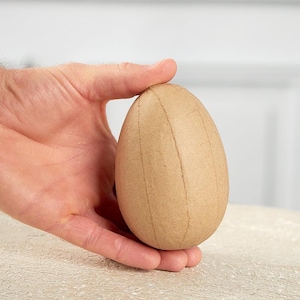 May include: A brown paper mache egg, perfect for crafting and decorating.