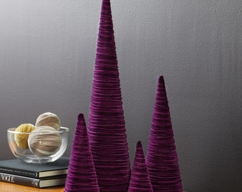 May include: Set of four purple velvet cone-shaped Christmas trees of varying sizes.