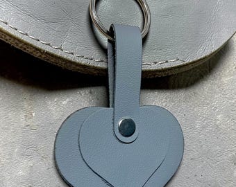 This is a gray leather 2 heart-shaped keychain featuring a layered design and a silver metal ring.