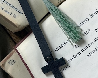 This is a handcrafted leather cross bookmark with a light green tassel.