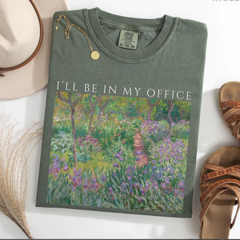 May include: A green t-shirt with a painting of a garden and the text "I'll be in my office" printed on the front.