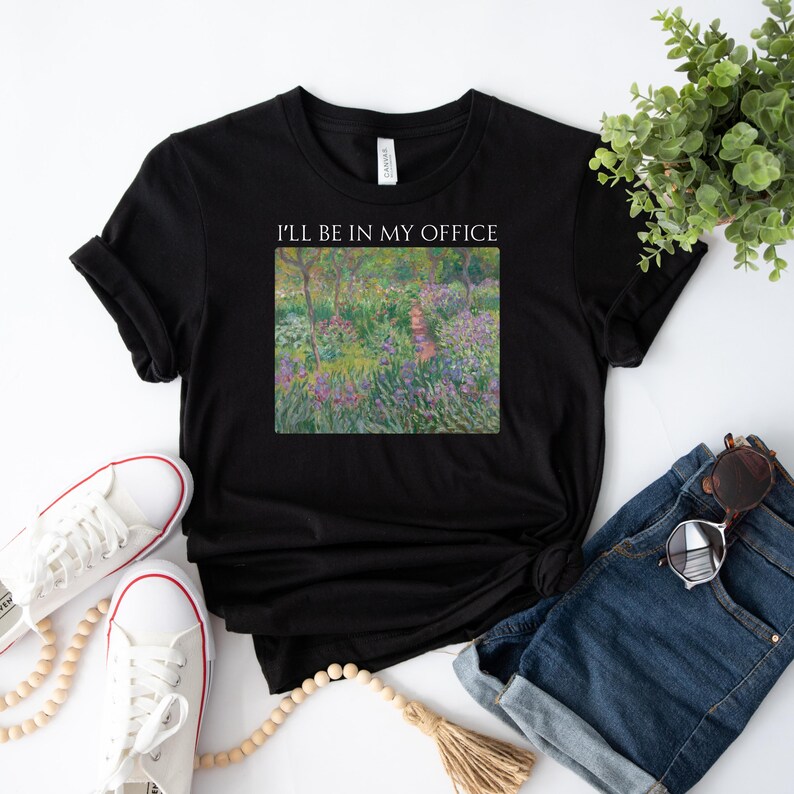 May include: Black t-shirt with the text "I'll be in my office" and a painting of a garden with a path.