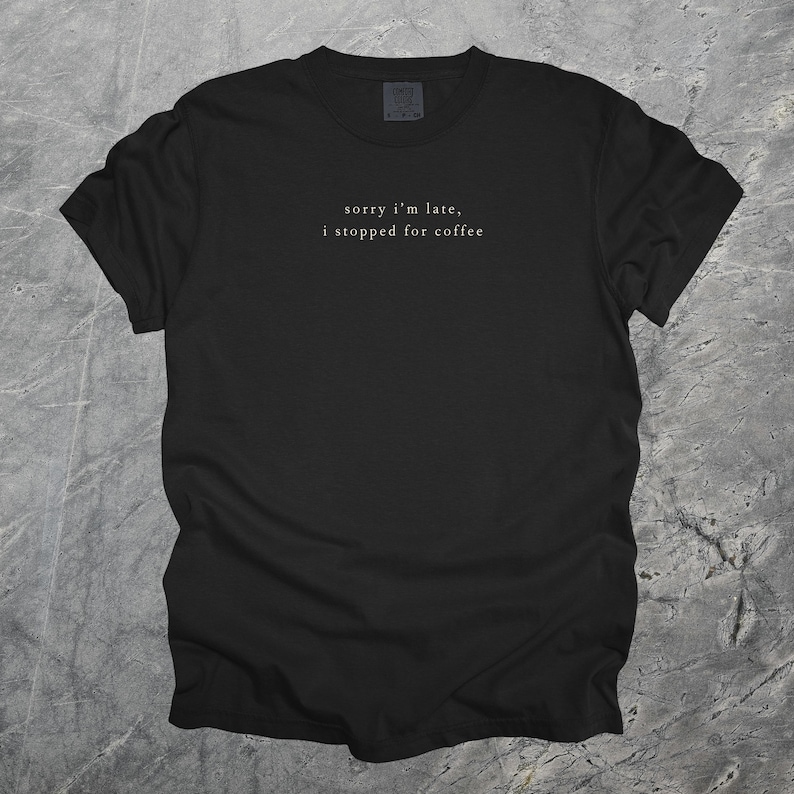 Puede incluir: Camiseta negra con la frase "sorry i'm late, i stopped for coffee" en una fuente sencilla y elegante. La camiseta est&aacute; hecha de un material suave y es adecuada para uso casual. El texto est&aacute; centrado en el pecho.