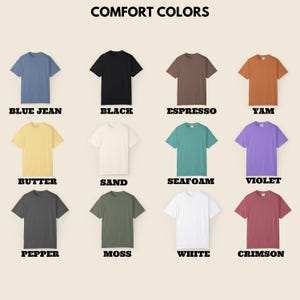 Puede incluir: Una colecci&oacute;n de camisetas de manga corta en varios colores, incluyendo azul vaquero, negro, espresso, &ntilde;ame, mantequilla, arena, espuma de mar, violeta, pimienta, musgo, blanco y carmes&iacute;. El texto "COMFORT COLORS" se muestra en la parte superior.