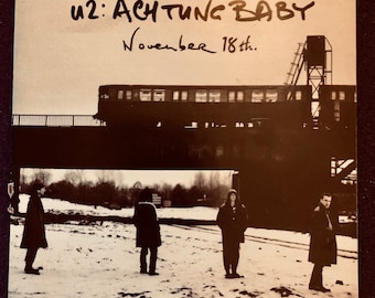 Promotieposter van U2 'Achtung Baby' - 18 november 1991 - Gevouwen miniposter van 30 x 30 cm - Zeldzaam promotiemateriaal - zo goed als nieuw! U2/Bono/The Edge/ALT