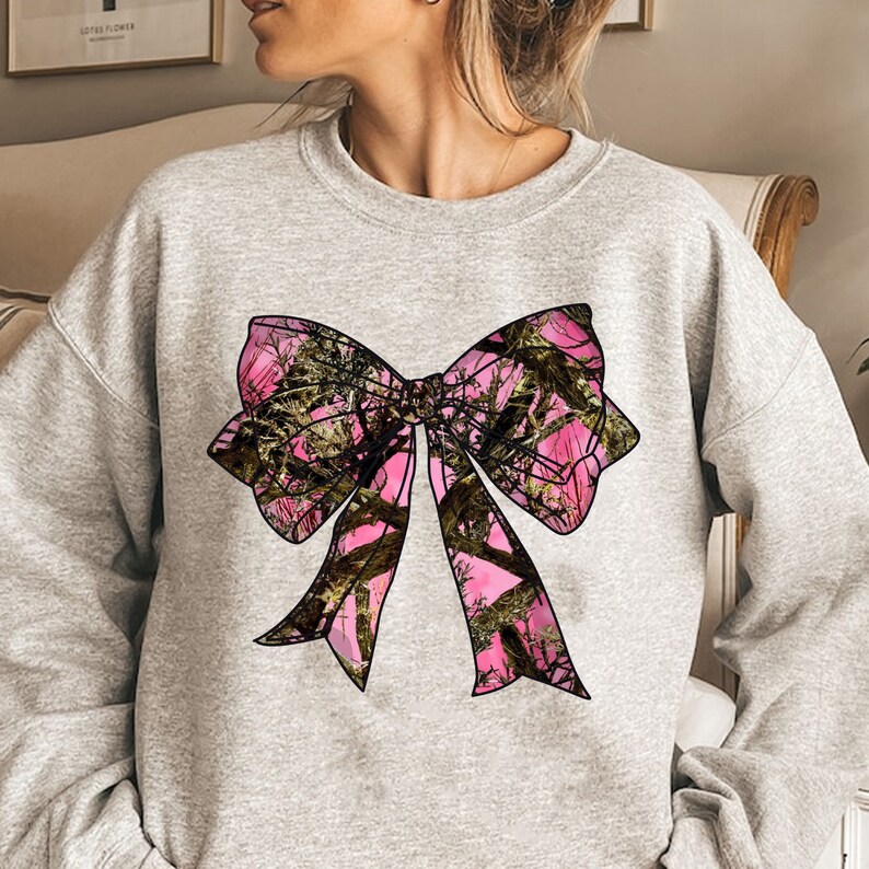 a woman wearing a sweatshirt with a pink bow on it