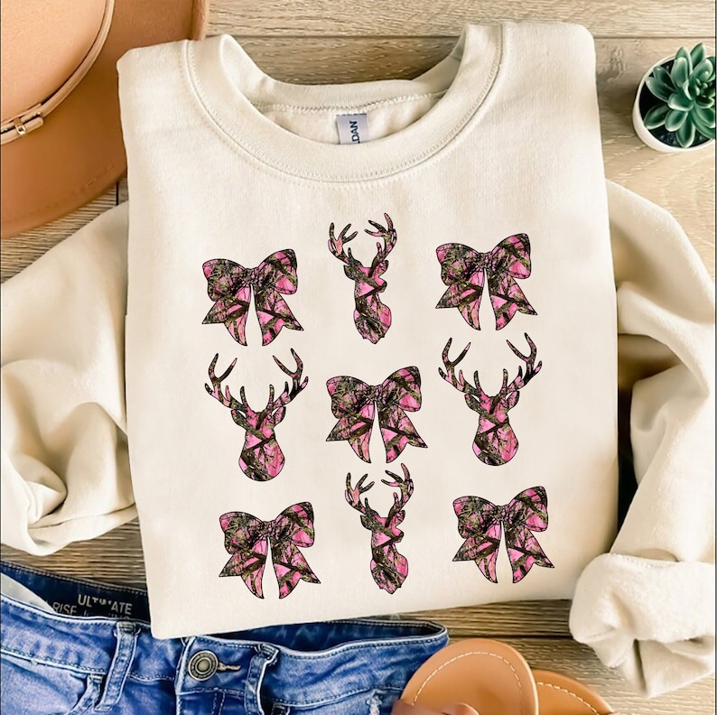 a white shirt with pink bows and deer heads on it