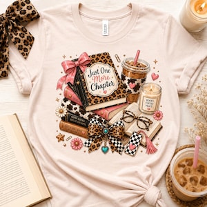 May include: A light pink t-shirt featuring a graphic print of a stack of books with a leopard print cover, a pink bow, a coffee cup, a candle labeled Books Coffee Peace, eyeglasses, and the text Just One More Chapter in a decorative font.