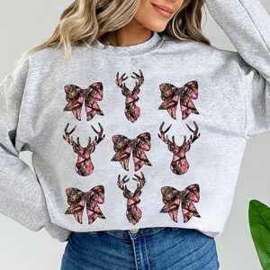 a woman wearing a sweatshirt with deer heads on it