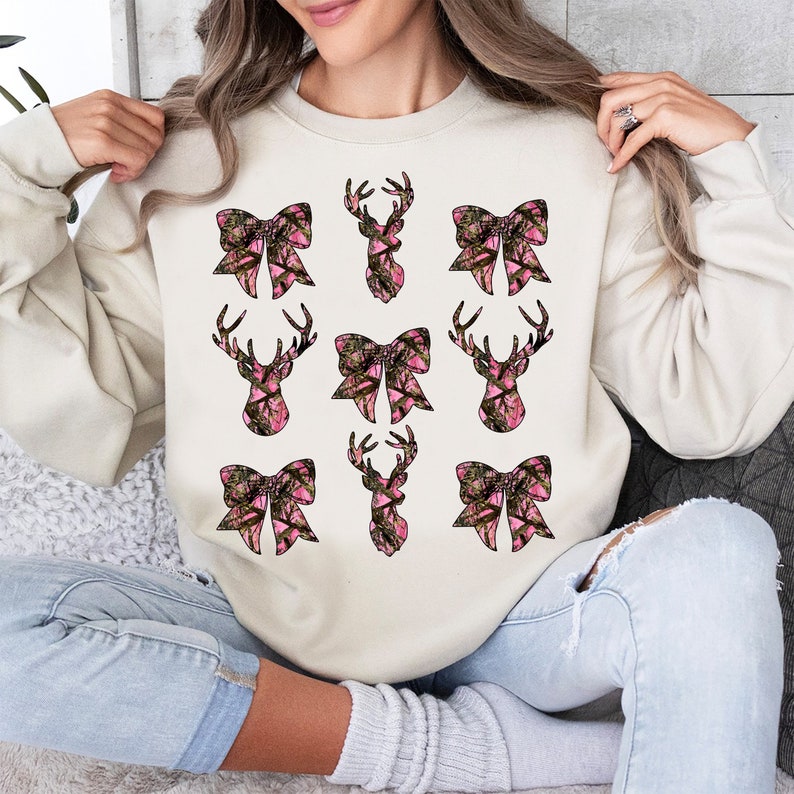 a woman sitting on a couch holding up a sweatshirt