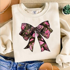 a white shirt with a pink bow on it