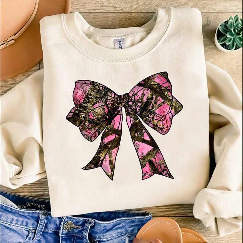 a white shirt with a pink bow on it