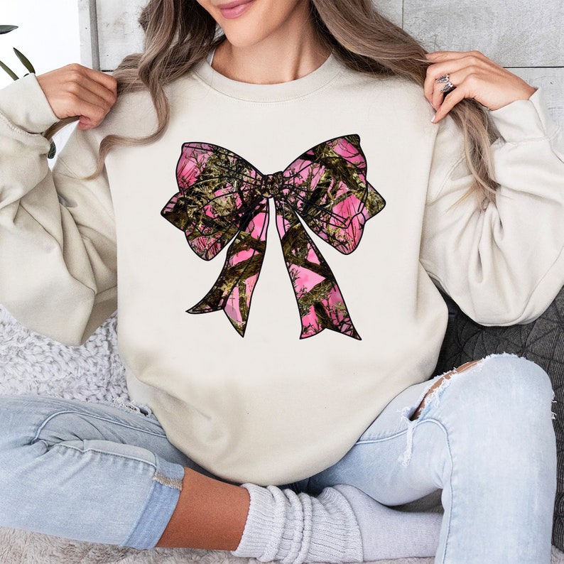 a woman wearing a sweatshirt with a pink bow on it