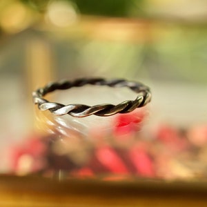 Peut inclure: Une bague en argent tressée avec un design simple.