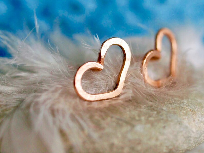 Puede incluir: Un par de pendientes de coraz&oacute;n de oro rosa. Los pendientes son delicados y simples, con un acabado liso.