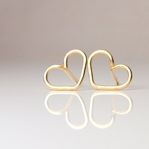Puede incluir: Dos pendientes de coraz&oacute;n de oro, cada uno con un dise&ntilde;o simple y abierto.