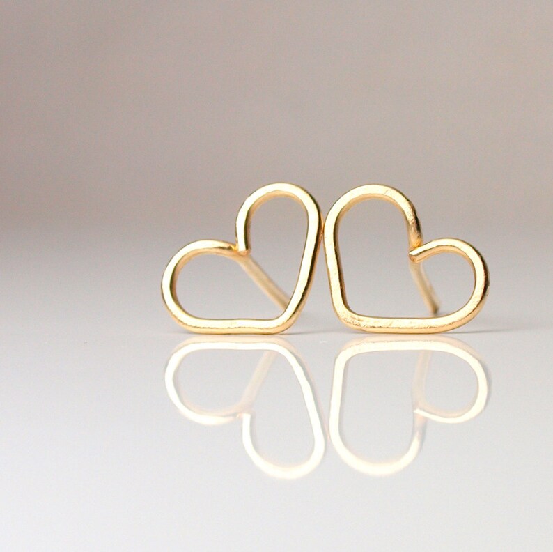 Puede incluir: Dos pendientes de coraz&oacute;n de oro, cada uno con un dise&ntilde;o simple y abierto.