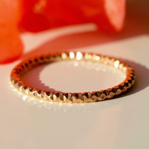 Peut inclure: Une bague en or avec un motif texturé en forme de diamant.