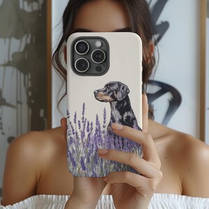 May include: A white phone case with a black dog illustration and lavender flowers. The dog is looking to the right and is standing in a field of lavender.
