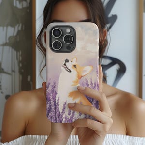 May include: A phone case with a cute illustration of a corgi dog looking up at the sky. The background is a soft purple with lavender flowers. The case is designed for an iPhone.